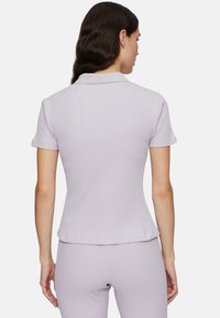 Lichtpaarse geribbelde polo met korte mouwen, aansluitend ontwerp en een klassieke kraag, met minimale naden en een gladde textuur.