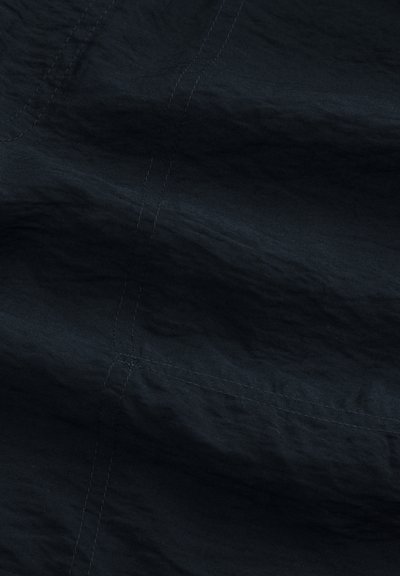 Dark navy fabric with visible stitching and slight wrinkles, highlighting texture and seam details.