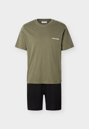 T-shirt vert olive Jack & Jones avec logo blanc sur la poitrine, associé à un short noir uni sur fond blanc.
