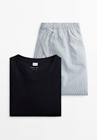 Sort bomulds T-shirt med rund hals, parret med blå stribede shorts med snoretræk. Begge dele er pænt arrangeret på en hvid baggrund.