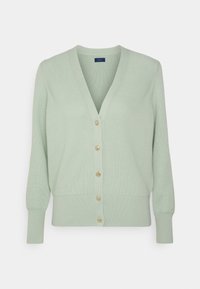 Cardigan a coste verde chiaro con scollatura a V, maniche lunghe e sei bottoni dorati sul davanti. Texture morbida con un punto vita aderente.