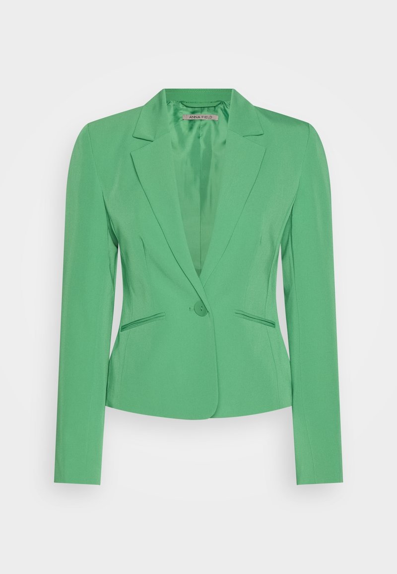 Blazer vert sur mesure avec une fermeture à un bouton, col à revers cranté, manches longues et deux poches avant passepoilées.