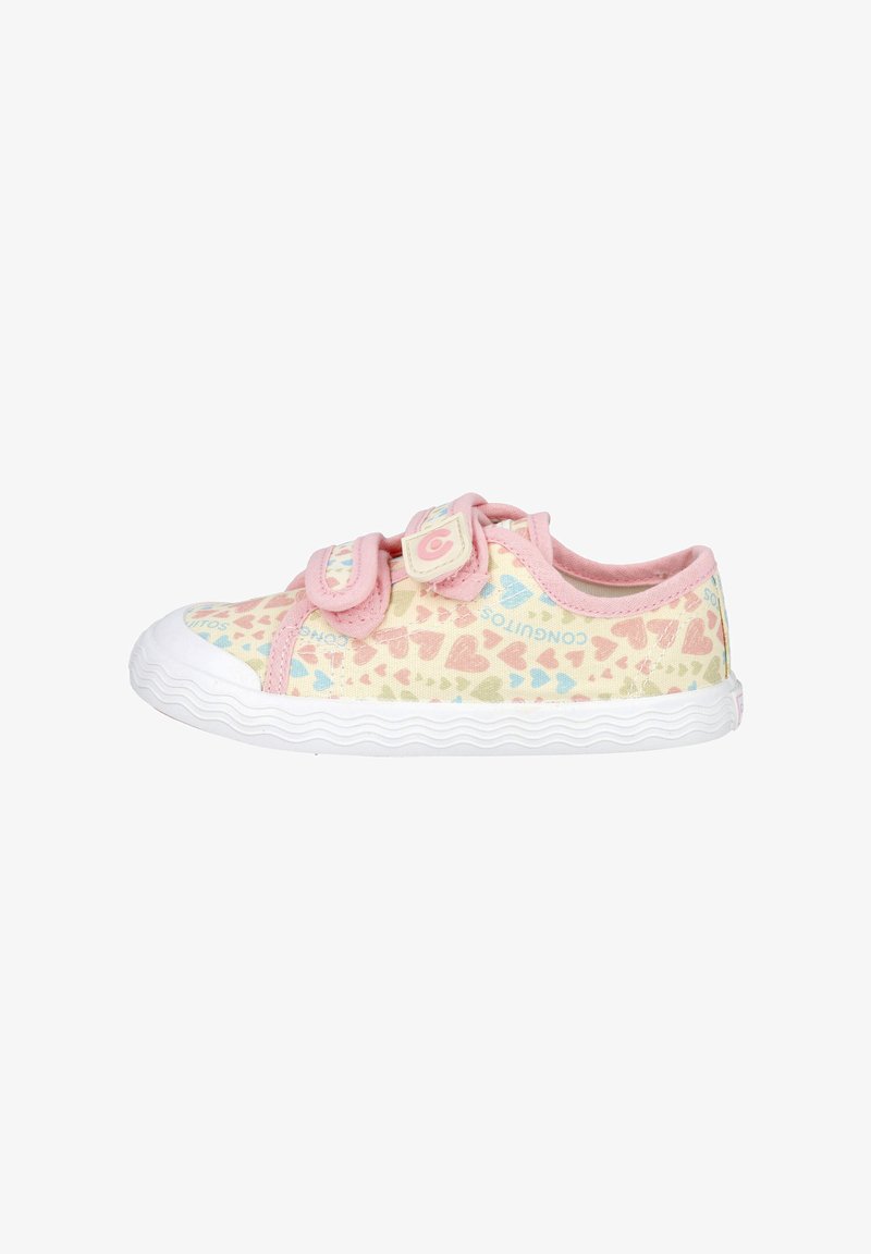 Zapatilla baja para niño con ribete rosa, dos tiras de velcro, suela blanca y patrón de corazones multicolores sobre una parte superior de tela color crema.