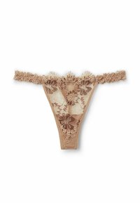 String en dentelle couleur nude avec motif floral, présentant des bords froncés et des panneaux en maille transparente. Tissu léger avec un design délicat et texturé.
