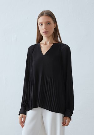 Top nero plissettato con scollatura a V, maniche lunghe e polsini con bottoni. Realizzato in tessuto leggero, presenta una silhouette fluida.