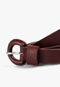 Correa de cuero burdeos con un anillo redondo y una lengüeta rectangular con detalle de calavera en relieve, textura suave y bordes cosidos.