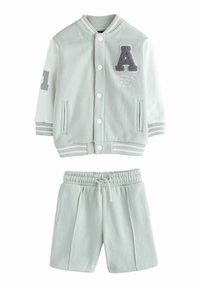 Ensemble de survêtement en mélange de coton gris clair comprenant une veste à boutons avec des poignets côtelés et un short assorti avec une taille élastique.