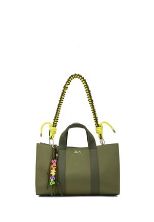 Borsa a mano verde oliva con manici verde scuro, tracolla intrecciata gialla e nera e portachiavi con perline colorate appeso di lato.