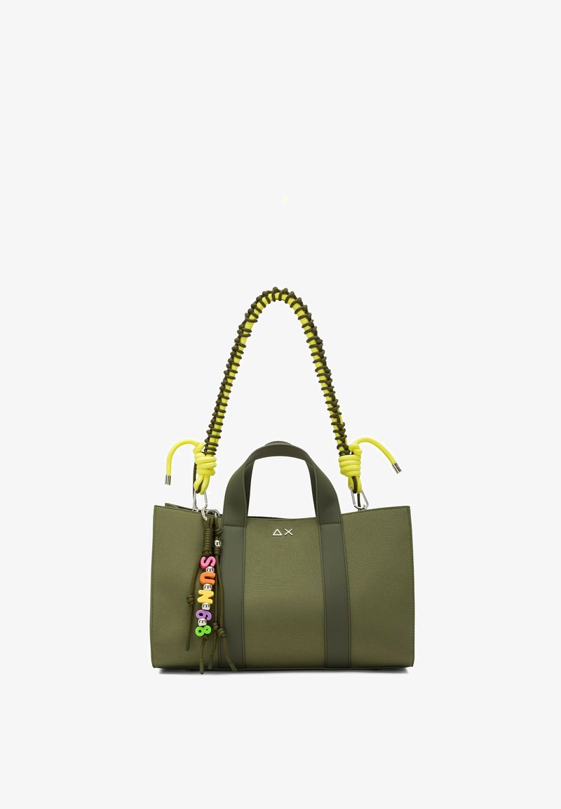 Borsa a mano verde oliva con manici verde scuro, tracolla intrecciata gialla e nera e portachiavi con perline colorate appeso di lato.