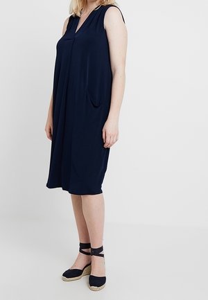 Marineblaues ärmelloses Kleid mit V-Ausschnitt und Seitentasche, aus leichtem Stoff; lockere Passform, knielang, glatte Textur.