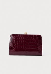 Καφέ πορτοφόλι από ψεύτικη κροκοδείλια υφή με γυαλιστερή φινίρισμα, διαθέτει χρυσό κούμπωμα στο επάνω μέρος για ασφαλή κλείσιμο.