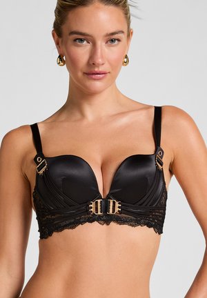 Zwarte satijnen push-up beha met kanten rand. Kenmerkt gouden hardware accenten en een U-vormig middenstuk. Verstelbare bandjes voor de perfecte pasvorm.