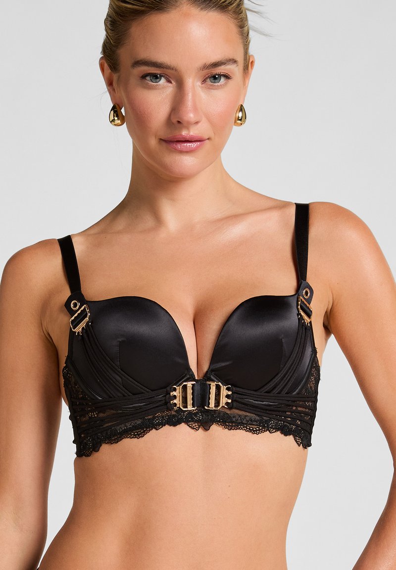 Sorte satin push-up bh med blondekant. Har guldfarvede hardware-detaljer og en U-formet midte. Justerbare stropper for pasform.