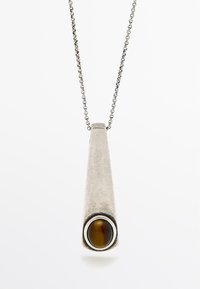 Collier pendentif en argent avec une forme effilée, mettant en valeur une pierre œil de tigre accentuée, entourée d'un anneau en métal sur le bas.