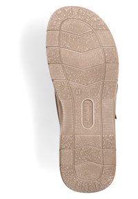 Semelle de chaussure en caoutchouc beige texturé, présentant un motif en zigzag pour l'adhérence et étiquetée avec la taille 41 et la marque "Rieker."