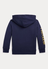 Námořnická modrá mikina s kapucí a dlouhými rukávy, s žlutým textem tištěným vertikálně na pravém rukávu, zobrazená zezadu.