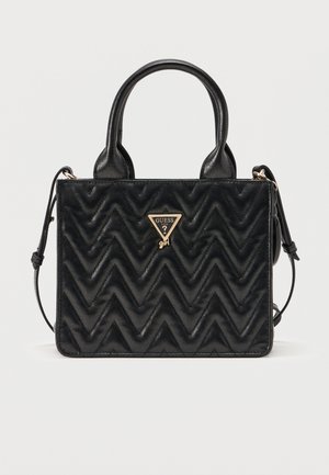 Schwarze gesteppte Handtasche mit Zickzackmustern, zwei Griffen, abnehmbarem Schulterriemen und goldfarbenem Guess Girl-Logo in der Mitte vorne.