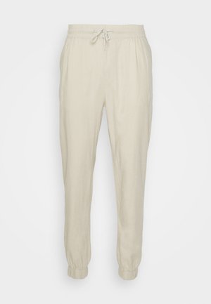 Beige linnen joggers met een elastische tailleband en verstelbare koord, voorzien van elastische boorden en een relaxte pasvorm. Soepele textuur.