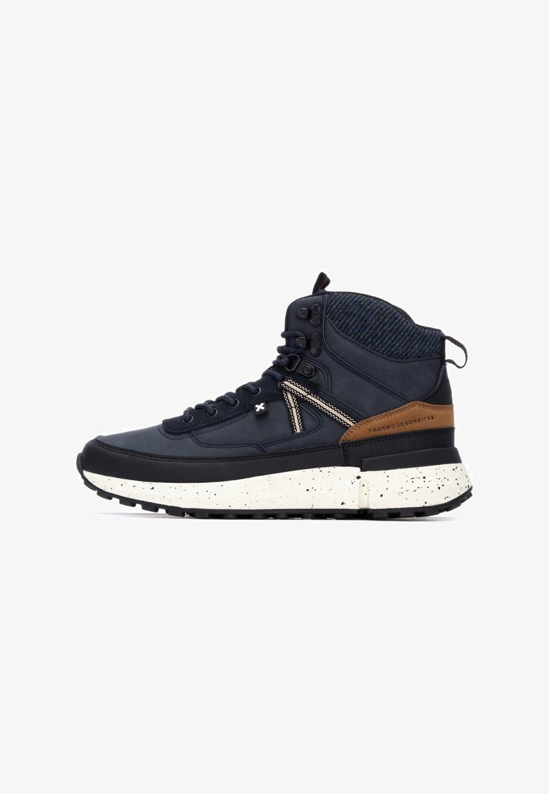 Zapatillas deportivas altas de color navy con un upper de cuero liso y textil, acentos en marrón, entresuela con motas blancas y suela de goma negra.