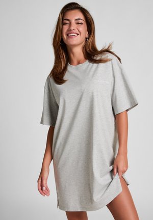 Gray oversized t-shirt dress made of soft fabric, featuring short sleeves and a small embroidered text on the chest, with side slits at the hem.