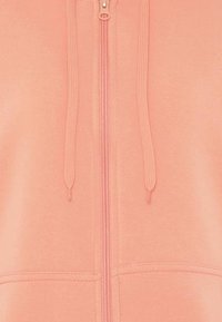 Lys pink zip-up hættetrøje lavet af blødt bomuldsblandingsstof, med snøre i hætten og frontlommer med subtile syningsdetaljer.