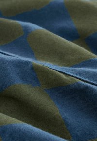 Țesătură cu pete abstracte mari în verde închis și albastru marin. Materialul pare moale, având o textură subtilă.
