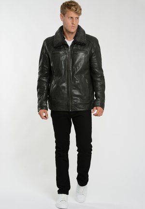 Sort læderjakke med en shearling krave, der har to lynlåslommer foran, strukturerede skuldre og en glat, blank finish.