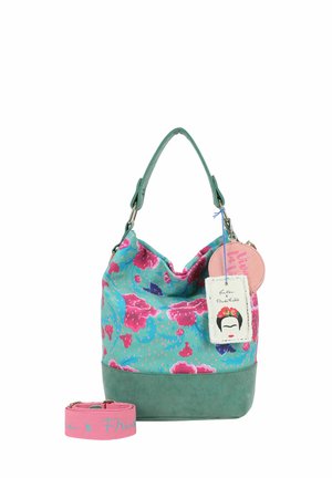 Sac à main floral turquoise et rose avec base et poignée vertes, doté d'une étiquette Frida Kahlo et d'une bandoulière rose assortie détachable.