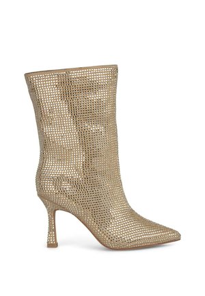 Botte à talon aiguille dorée avec un design en maille ouverte, bout pointu et talon fin. Surface texturée avec des perforations régulières.