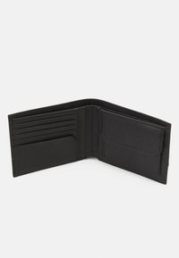 Portafoglio in pelle nera con più scomparti per carte, una tasca laterale e una superficie liscia. L'interno è cucito in modo ordinato con un design minimalista.