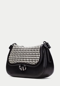 Sort læderhåndtaske med en houndstooth-mønstret tekstilklap, udstyret med et sølvfarvet hardware-logo og justerbar rem. Glat overflade generelt.