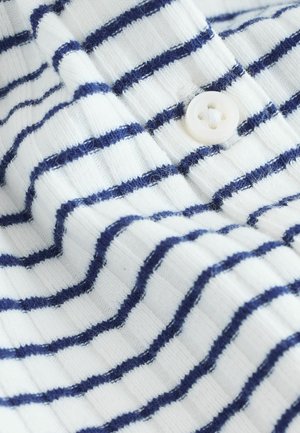 Balts audums ar zilām horizontālām svītrām, ribota tekstūra un redzams balts pogas detalizējums. Tuvplāna skats, kas izceļ materiālu un rakstu.