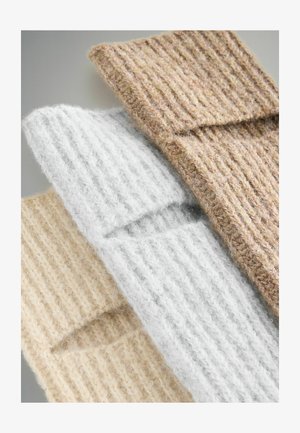 Three knitted fabric swatches in beige, light gray, and brown, featuring a ribbed texture and visible fibers.