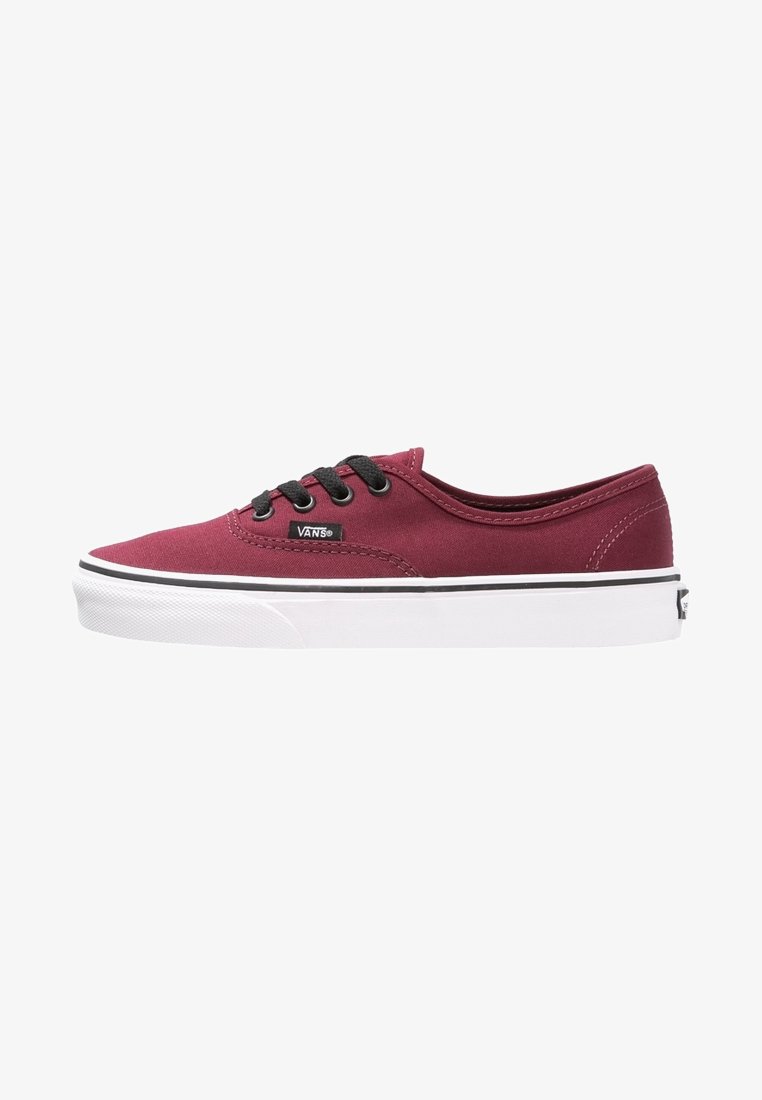 Baskets basses Vans bordeaux avec lacets noirs et semelle blanche en caoutchouc, vues de côté montrant l'étiquette de la marque et les détails de couture.