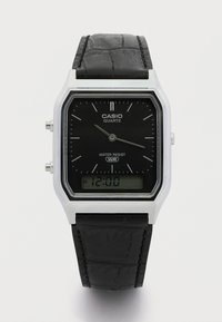 Casio křemíkové hodinky s obdélníkovým stříbrným pouzdrem, černým analogovým a digitálním displejem, černým strukturovaným koženým páskem a funkcí odolnosti vůči vodě.