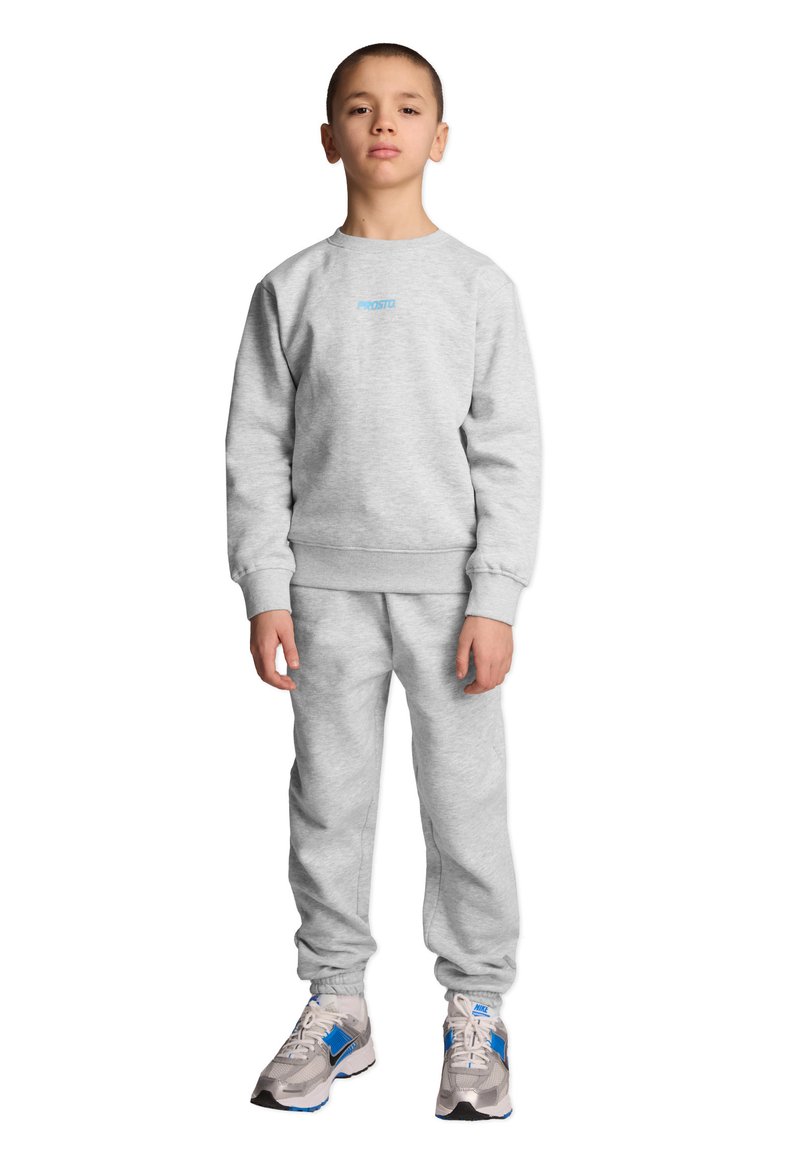 Szary zestaw składający się z bawełnianej bluzy i spodni dresowych, z prążkowanymi mankietami oraz małym niebieskim logo na piersi. Szczegóły obejmują elastyczne mankiety przy kostkach.