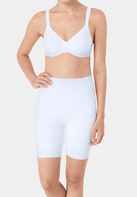 Soutien-gorge blanc sans couture avec larges bretelles et texture lisse, associé à un short taille haute moulant blanc qui descend jusqu'au milieu de la cuisse.