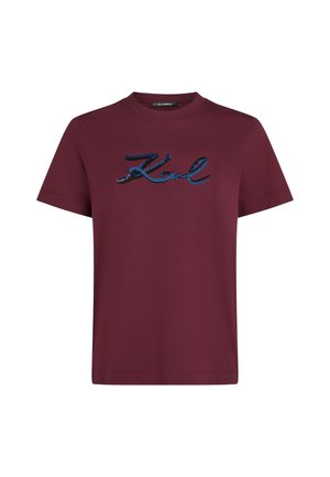 Burgundy t-shirt made of cotton, featuring a blue sequined cursive "Karl" logo across the chest. Short sleeves and crew neck design.