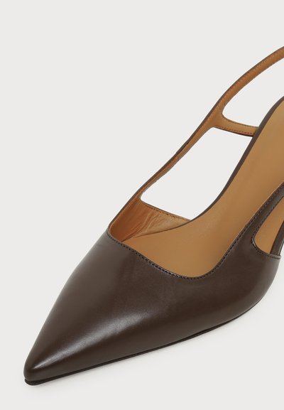 Mørkebrune skinn slingback-sko med spiss tupp og lys brun innerfôr, og en tynn stropp over hælen på hvit bakgrunn.