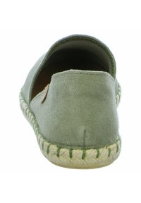 Espadrille de ante verde con parte trasera redondeada, diseñada con una suela de yute natural y costuras en contraste a lo largo del borde de la suela.
