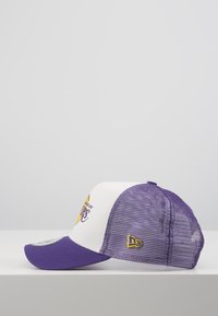 Lila und weiße Baseballmütze mit Netzrücken, die ein Logo auf der Vorderseite hat. Der Schirm ist dunkel-lila, mit einem gelben Akzent an der Seite.