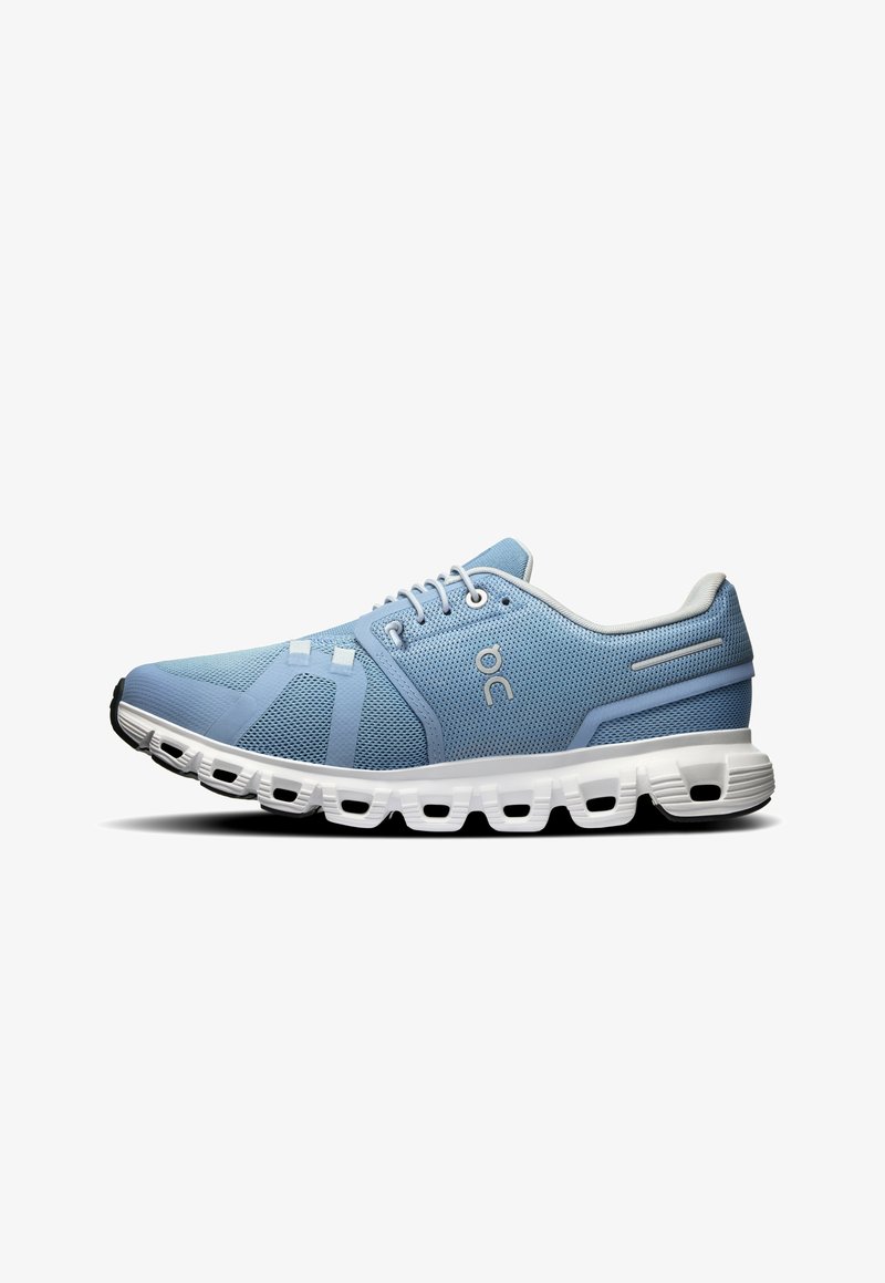 Light blue athletic shoes with a mesh upper, featuring a white sole with distinctive cutouts and stitched detailing.