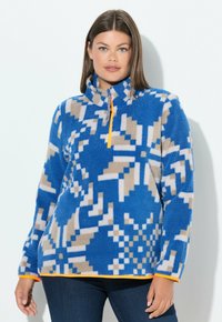 Niebieska bluza polarowa z geometrycznymi wzorami, z wysokim kołnierzem, pomarańczowym zamkiem błyskawicznym i kontrastowym pomarańczowym obszyciem. Miękki i teksturowany materiał.