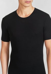 T-shirt nera a maniche corte realizzata in tessuto morbido, con scollatura a girocollo e un design fitted che si adatta al corpo.