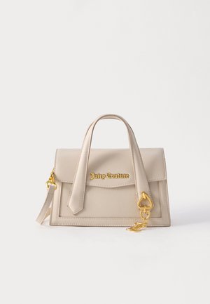 Μπεζ τσάντα Juicy Couture με χερούλια στην κορυφή, χρυσό λογότυπο και χρυσό γούρι σε σχήμα καρδιάς σε απλό λευκό φόντο.