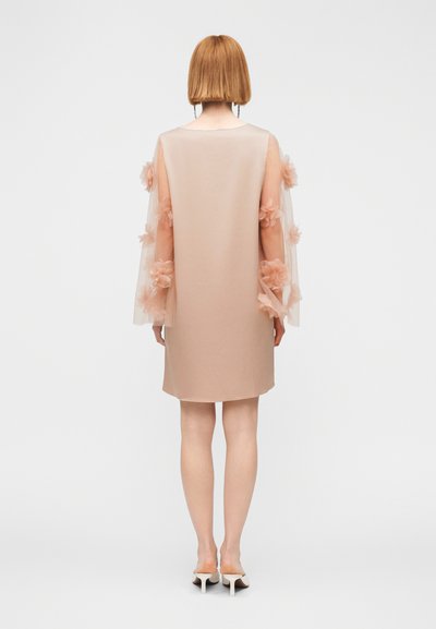 Φόρεμα ανοιχτό ροζ με διαφανή, διακοσμημένα μανίκια που έχουν υφασμάτινα λουλούδια. Άμεση, μέχρι το γόνατο γραμμή με ομαλή υφή.