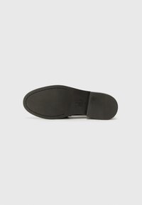 Black leather shoe sole with smooth texture, rounded shape, and stitched accents. Features a logo and size "37" embossed on the side.