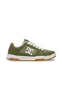 Χαμηλό sneaker σε ελιά πράσινο με λευκά κορδόνια, λευκή και καουτσούκ σόλα και μεγάλο λευκό λογότυπο DC στη πλευρά.
