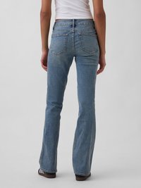 Jean évasé en denim bleu clair avec une taille haute, comprenant deux poches arrière et des détails de couture subtils. Texture lisse avec une coupe classique.