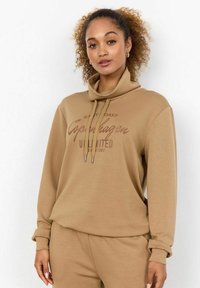 Bruine sweatshirt met een hoge kraag, voorzien van een grafische tekstpresentatie in donkerder bruin. Gemaakt van zachte, geweven stof. Ruimvallende stijl.
